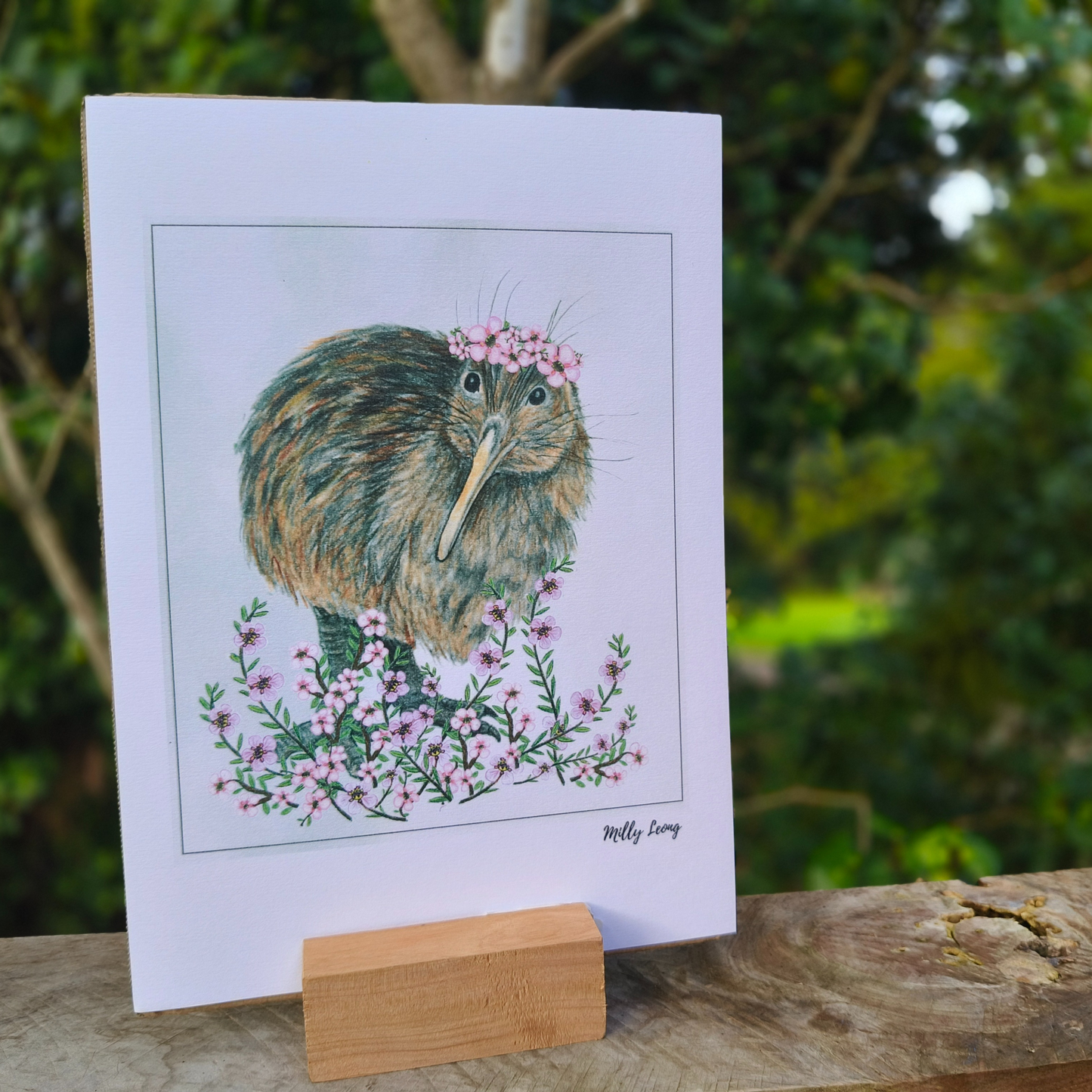 A4 art print with a kiwi bird illustration on a wooden stand outdoors