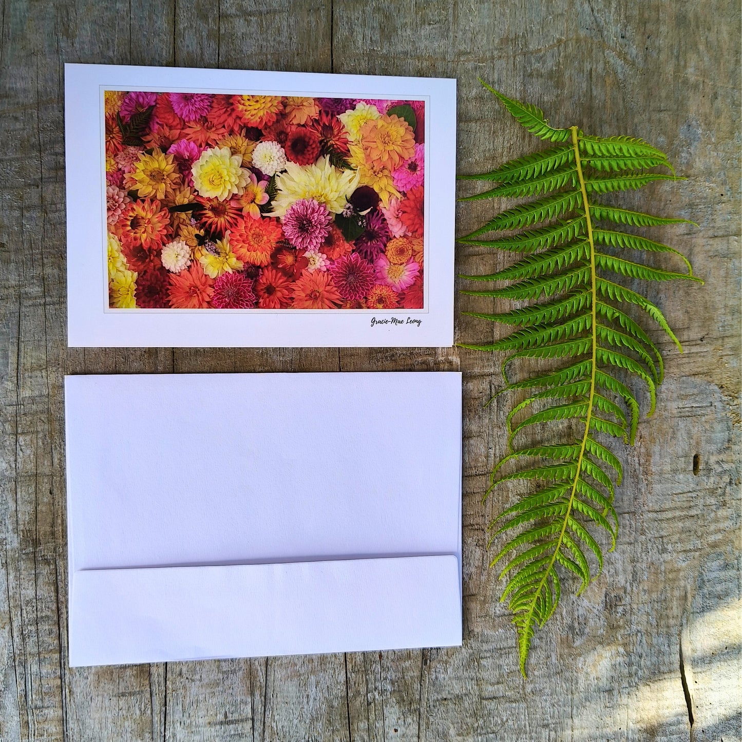 Greeting card featuring bright orange dahlia flatlay by Gracie-Mae – blank inside