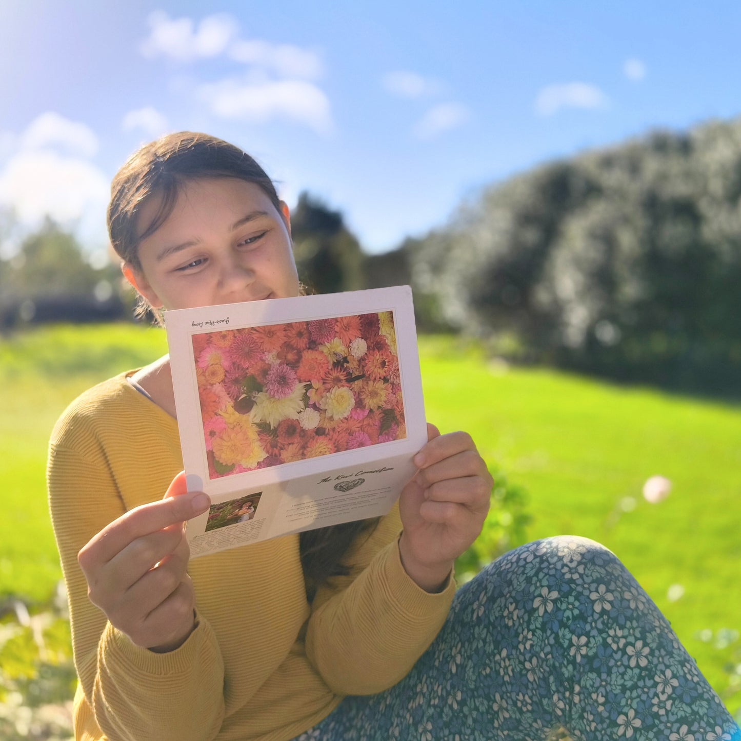 Greeting card featuring bright orange dahlia flatlay by Gracie-Mae – blank inside