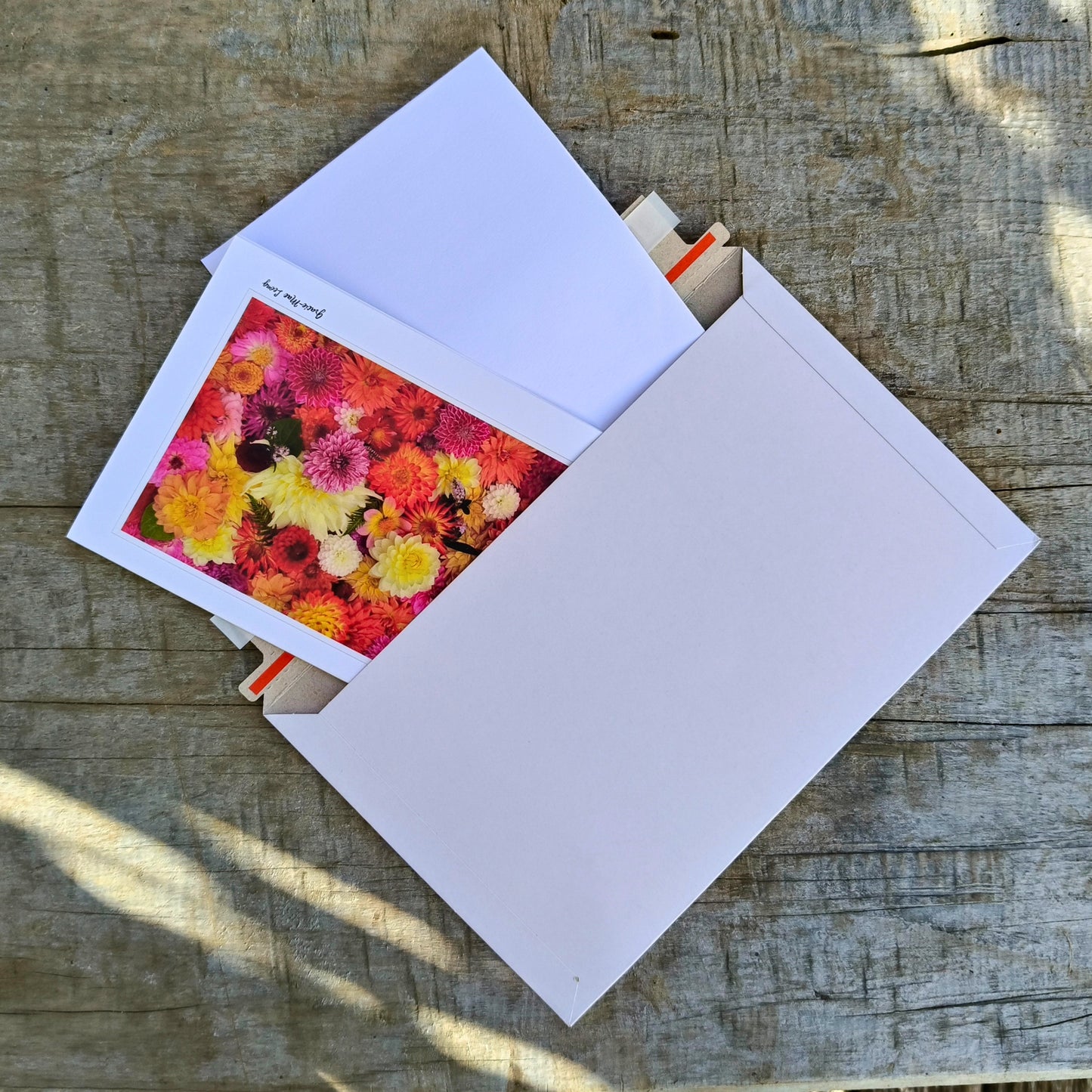 Greeting card featuring bright orange dahlia flatlay by Gracie-Mae – blank inside