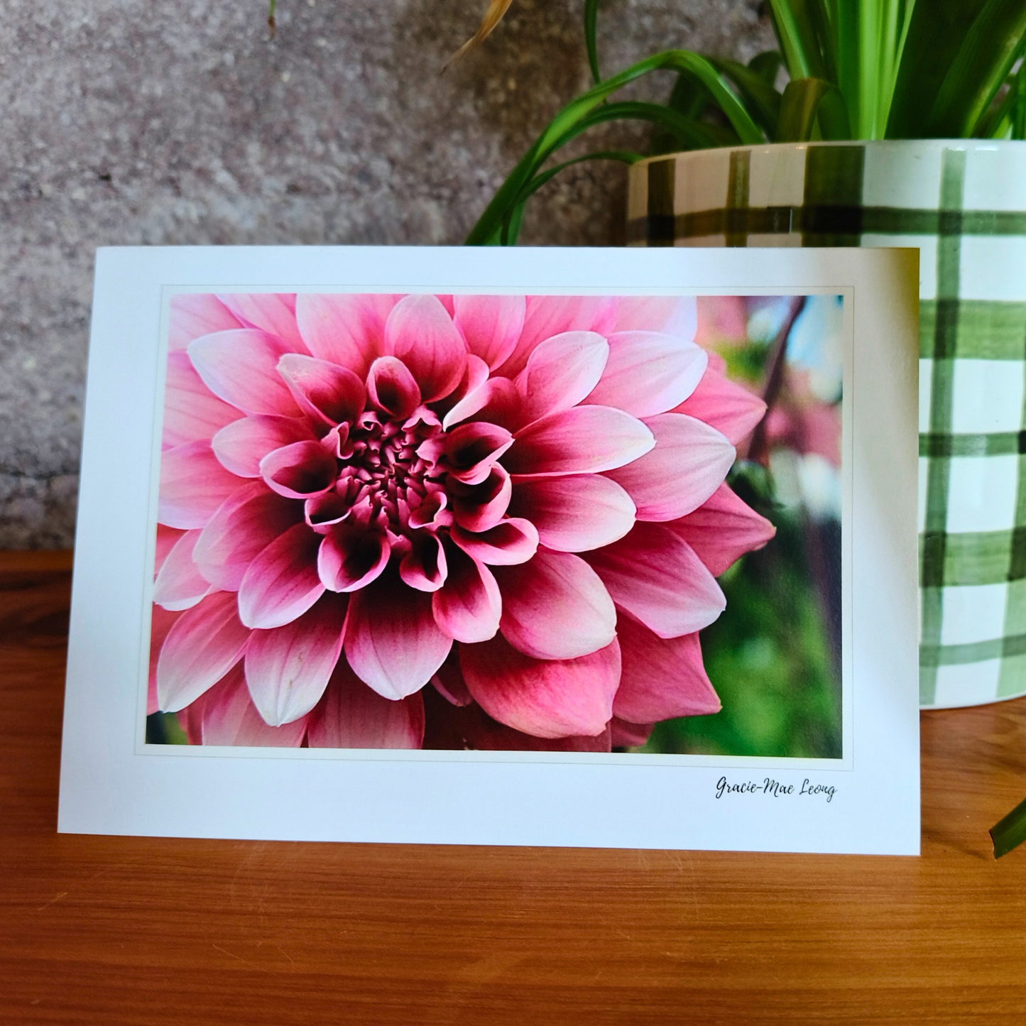 Card with a pink flower design on a wooden surface