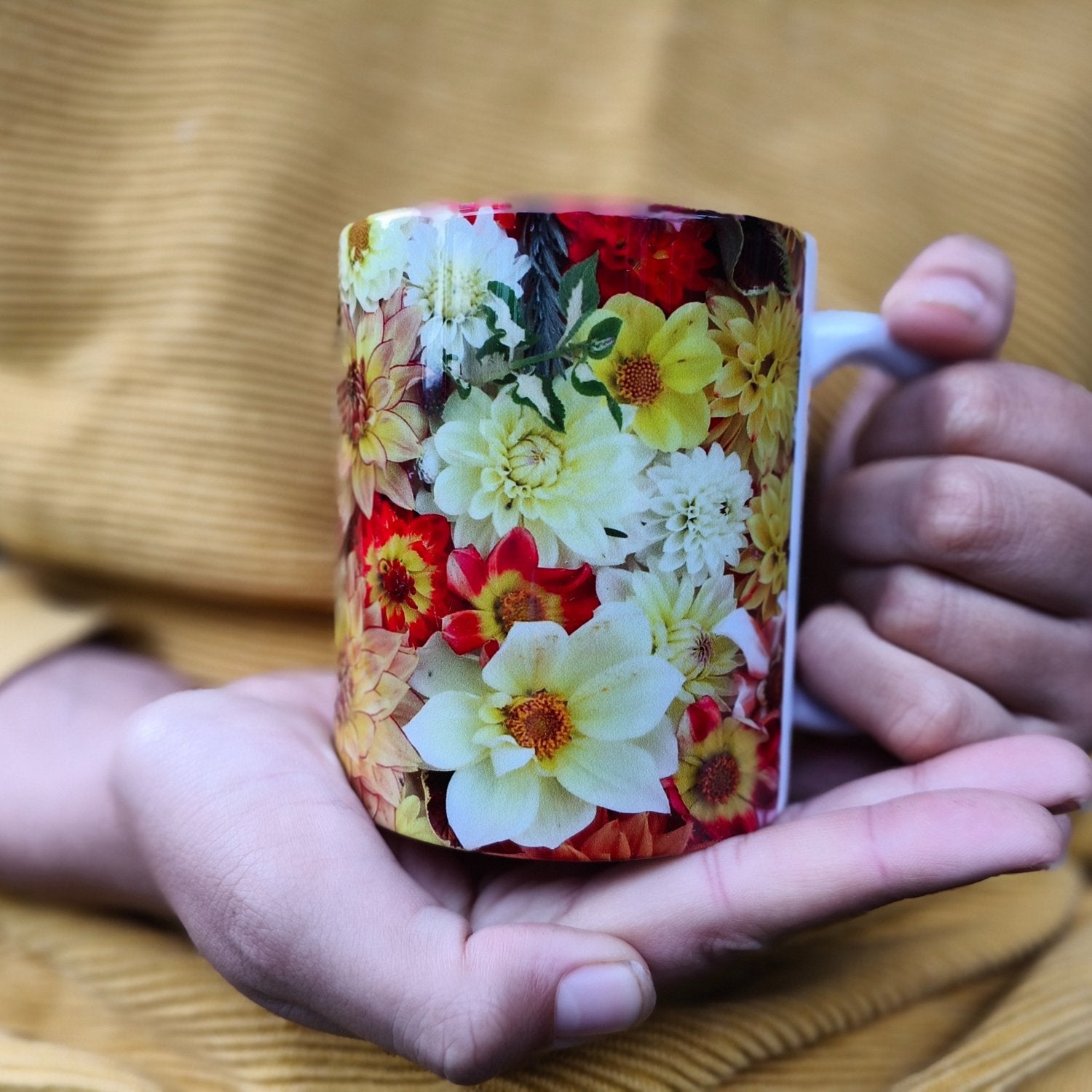 A bright cheeful mug with sunny dahlias wrapping all around it bred and photographed by Gracie-Mae Photography.